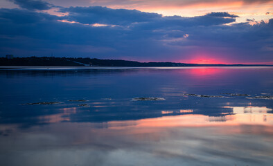 Sunset over the Kyiv Sea expressing contrast: beautiful sunset and polluted dirty water. Ecological concept