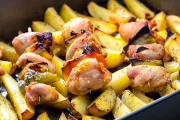 skewers with meat, onion and pepper on baked potatoes