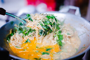 Traditional spicy curry soup of pickled bamboo shoot with chilly paste, basil and fried tofu in the pan.
