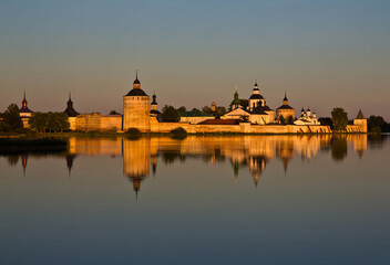 Fototapeta premium The view on the Kirillo-Belozersky Monastery reflecting in the river at sunset in Vologda region, Russia.