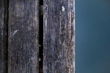 Fototapeta premium Ein abstraktes Bild eines alten Holzsteges der sich über dramatisch blauem Wasser befindet