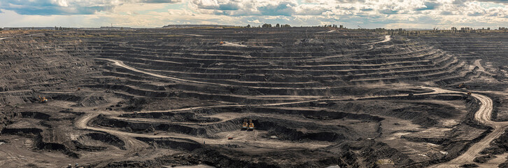 Panoramic aerial view of coal mine. Open pit mine industry, big yellow mining truck for coal...
