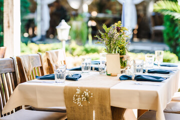 Outdoor wedding table decoration with fresh flowers and blank table cards. Special event table set up. Boho wedding decoration.