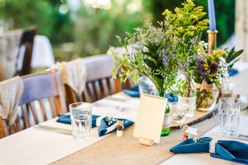 Outdoor wedding table decoration with fresh flowers and blank table cards. Special event table set up. Boho wedding decoration.