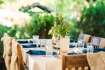 Outdoor wedding table decoration with fresh flowers and blank table cards. Special event table set up. Boho wedding decoration.