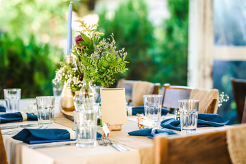 Outdoor wedding table decoration with fresh flowers and blank table cards. Special event table set up. Boho wedding decoration.