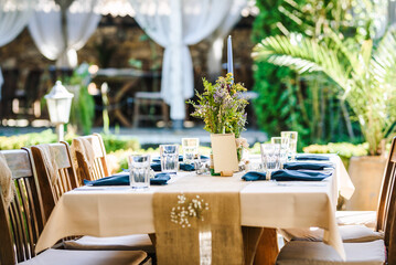 Outdoor wedding table decoration with fresh flowers and blank table cards. Special event table set up. Boho wedding decoration.
