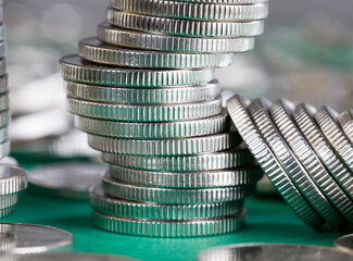 metal coins stacked together on a green background