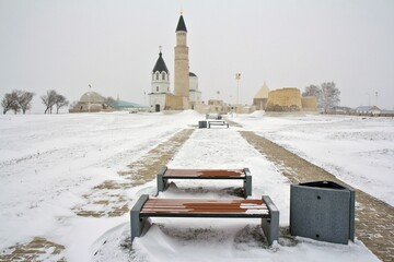 Dormition Church and a Mosque nearby in snowy winter in the museum-town Bolgar in Tatarstan, Russia.