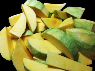 Pile of Chunks of Ripe Yellow Mangos Isolated on Black