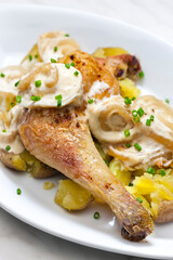 chicken leg on creamy onion sauce with potatoes
