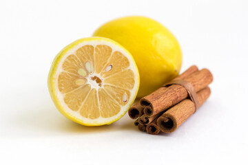 Lemon and cinnamon sticks on a white background.