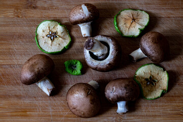 Mushrooms and dried apple slices on a wooden table