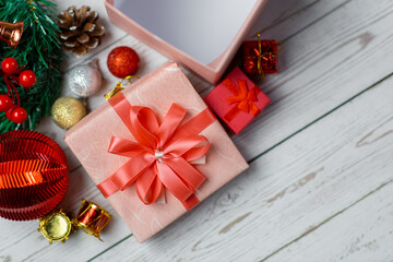 Closeup of pink gift box and Christmas composition on a wood background. Layout Christmas background concept.