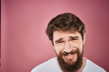 bearded man in white t-shirt emotions displeased facial expression studio pink background