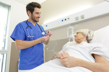 nurse talking to senior patient in hospital room