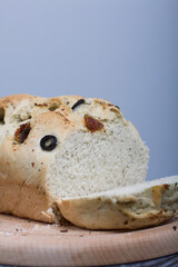 Focaccia bread with olives and sun-dried tomatoes. On a light background. Close-up.