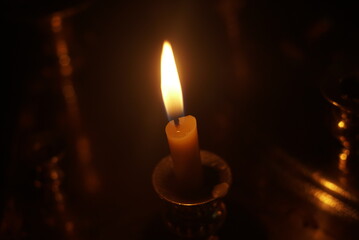candle burning on a candlestick in the church close up