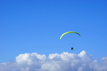 Paraglider over the sunny clouds