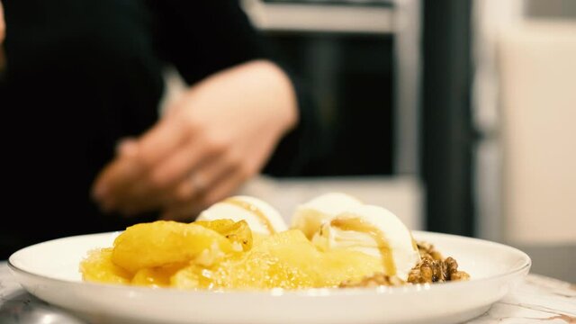 Girl sit down at the table with ice cream dessert
