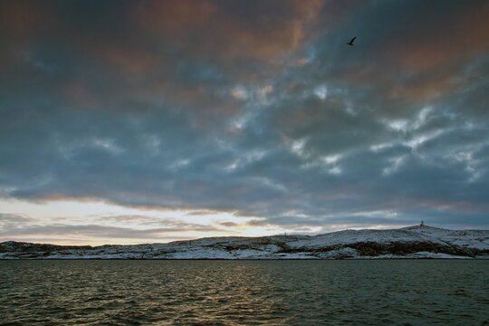 Barents Sea, hills covered with snow and cloudy sky in winter in Severomorsk, Russia.