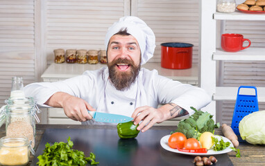 Cook cut vegetable. Cooking. Cutting and chopping. Handsome bearded chef in uniform. Ingredients. Professional kitchen.