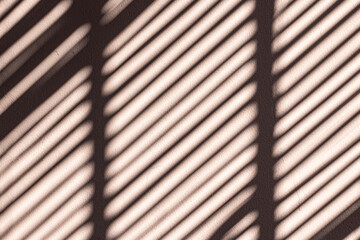 Blind shadows on the wall. Jalousie shadows on the textured background. Sunny day.