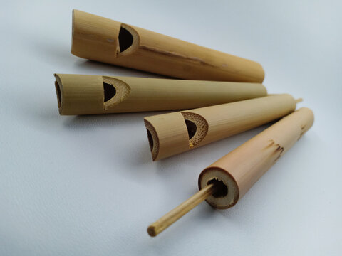 Traditional regional inflatable instruments from Indonesia. Made of bamboo. It is unique and produces a melodious tone of voice. Shaped like a flute. Isolated on white background.