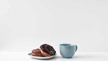 Mug and donuts cakes on a white background. Confectionery, coffee shop. Copy space, mock up.