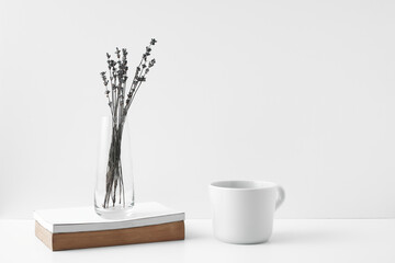 Mug and transparent vase with flowers on a white background. Eco-friendly materials in the decor of the room, minimalism. Copy space, mock up.