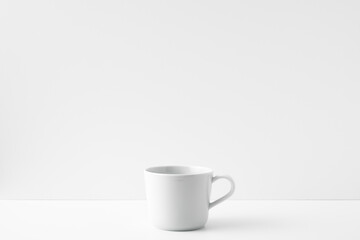 The mug stands on a white table on a white background. Copy space, mock up