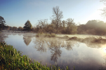 Fototapeta na wymiar A still River Wey on a cold sunny morning in Godalming, Surrey, UK