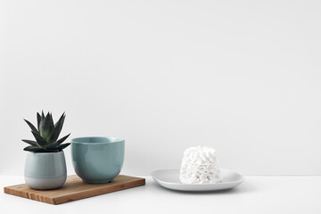 Blue mug and meringue cake on a white background. Eco-friendly and natural materials in decor and interior design, dessert. Copy space, mock up.