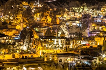 Beautifully illuminated at night buildings of Gorme, city built among rock formations. Cappadocia, Turkey. It is a famous center of balloon fligths..