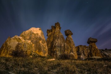 Massive volcanic rock formations under star sky in early morning. Cappadocia, Turkey. This rocky...