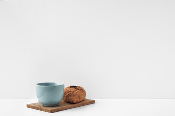 Blue mug and croissants on a white background. Eco-friendly and natural materials in the decor, dessert. Copy space, mock up.