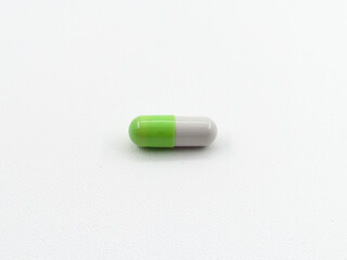 Close up of green and white pills capsule isolated on white background. Health care, medical, pharmacy concept