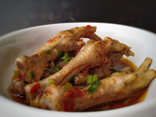 Chicken claw curry served in a white bowl.  Very delicious and spicy