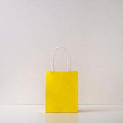 Gift yellow paper bag on a white background. Copy space, flat lay, mock up, top view