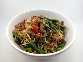 Indonesian food. Stir-fry the beef with sprouts and long beans, which are mixed with fresh red chilli pieces. Isolated on white background