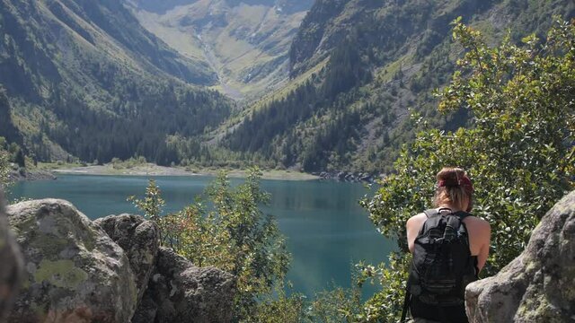 Stunning shot of a young Caucasian woman enjoying a clear lake in a mountain range