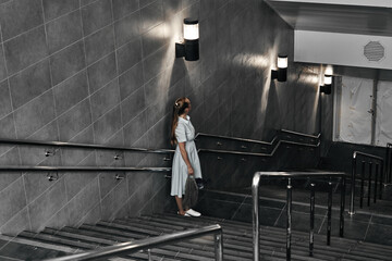 Girl on the stairs down, late transition, subway. One person on the descent into the underpass.