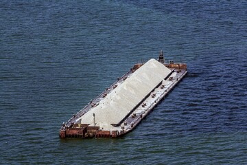 Aerial view of barge with white gravel waiting for unloading in cargo port of Ulyanovsk. The river...