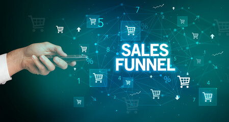 hand holding wireless peripheral with SALES FUNNEL inscription, online shopping concept