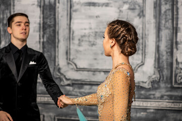 young couple in evening dance costumes dancing tango in the ballroom
