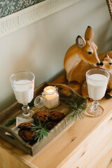 Chocolate chip cookies on a tray with milk in glasses on a christmas holiday row with a deer figurine