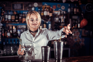 Charismatic girl barman makes a cocktail in cocktail bars