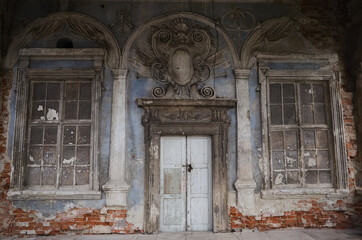 Old entrance doorway with emblem above on right side of ancient fortress castle in village of Pidhirtsi in Lviv region, Ukraine
