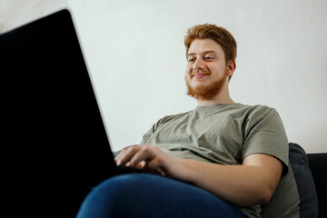 young ginger person with laptop