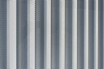 Background of white metal columns with evenly placed holes